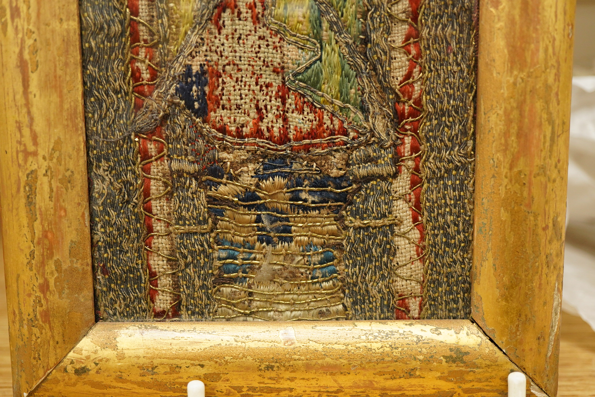 An early 16th century ‘Opus Anglicanum’ (English work), silk and metal thread embroidered fragment, of Saint Andrew, possibly cut from an orphrey, later framed and glazed, 28.5cm high x 9.5cm wide. Condition - the silk t